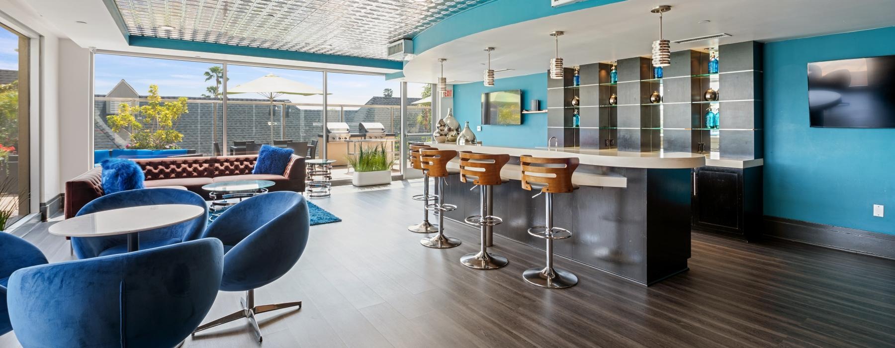 a room with blue chairs and a bar