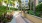 a walkway between buildings surrounded by plants